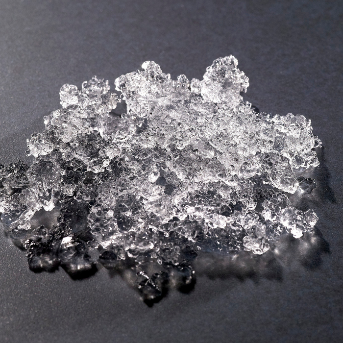 Hoshizaki ice flakes on dark surface.