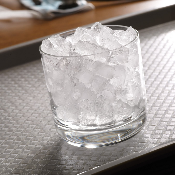 Cubelet ice in a glass on a gray tray.