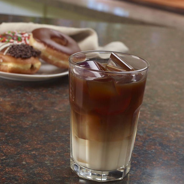 Hoshizaki DKM-500BWJ Crescent Cuber, water-cooled ice machine, built-in storage bin, glass of iced coffee and donuts on a counter.