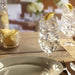 Water glasses filled with ice cubes and lemon wedges on a wooden table.