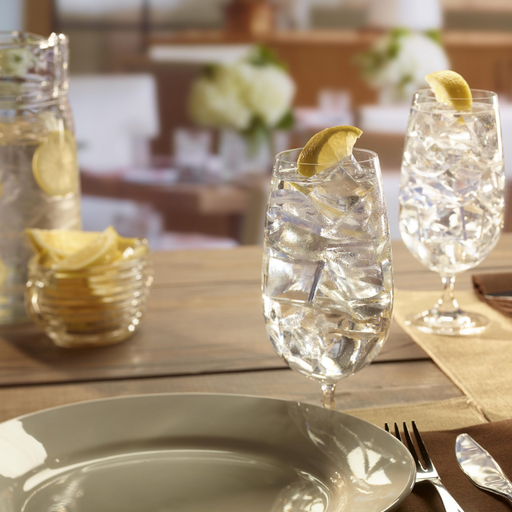 Glasses of water with lemon slices on a table, featuring crescent-shaped ice cubes.