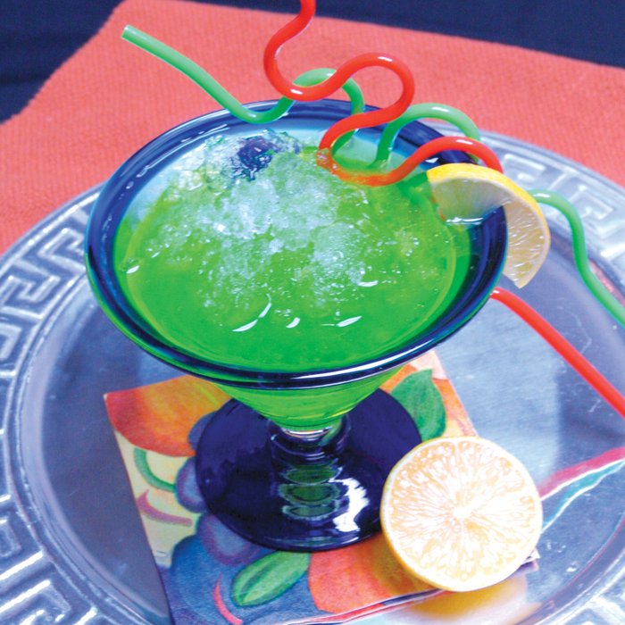 Green cocktail with flaked ice in a glass, garnished with a lemon slice and colorful straws.