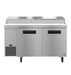 Two-section pizza prep table with stainless doors, featuring refrigerated storage and cutting board.